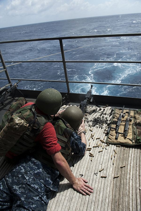 Một xạ thủ đang bắn hoả lực từ súng máy M240, trong khi một binh sỹ khác đang quan sát mục tiêu trên bong tàu sân bay USS John C. Stennis (ảnh ngày 31/8/2011).